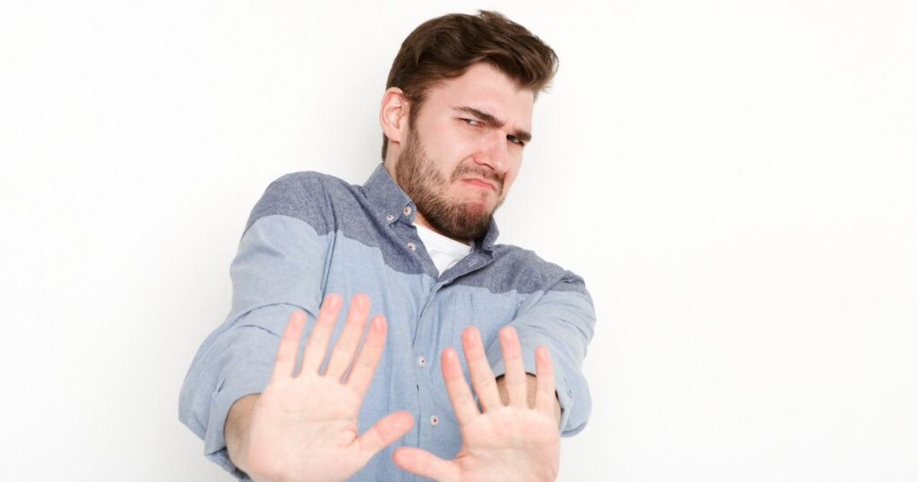 両手を前に突き出し拒否する男性