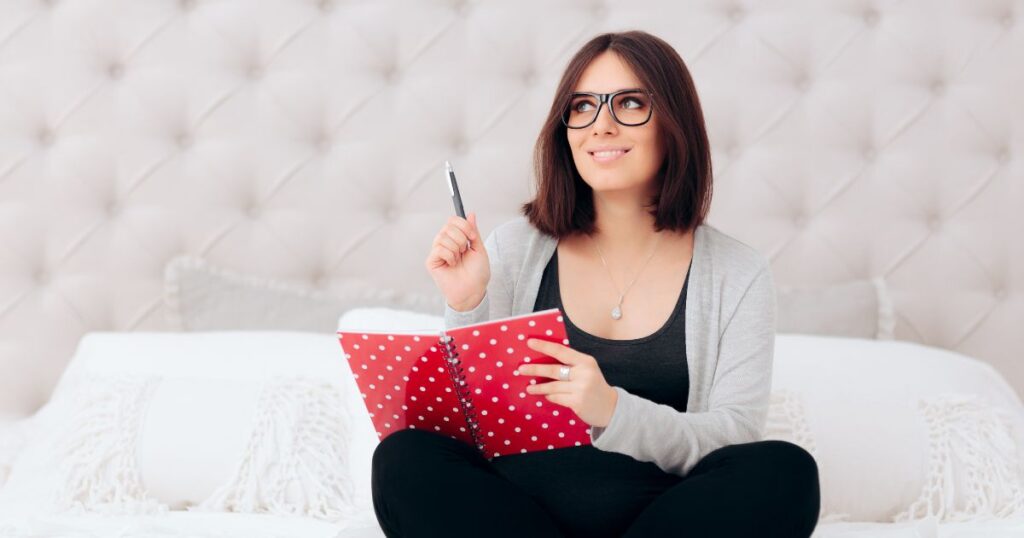 日記を持って書くことを考えている女性