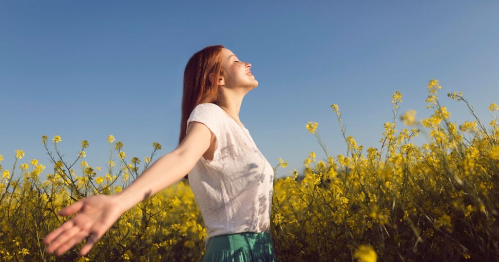 花畑で手を広げる女性