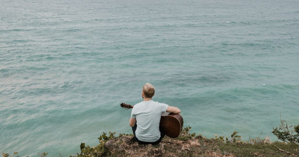 海辺で遠くを見つめる男性