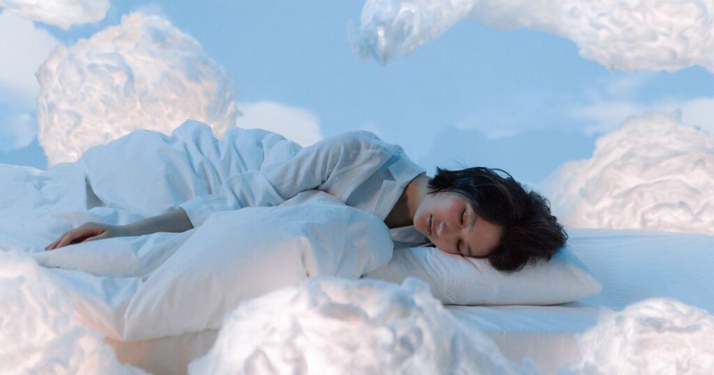 夢の中で雲に囲まれながら眠る女性