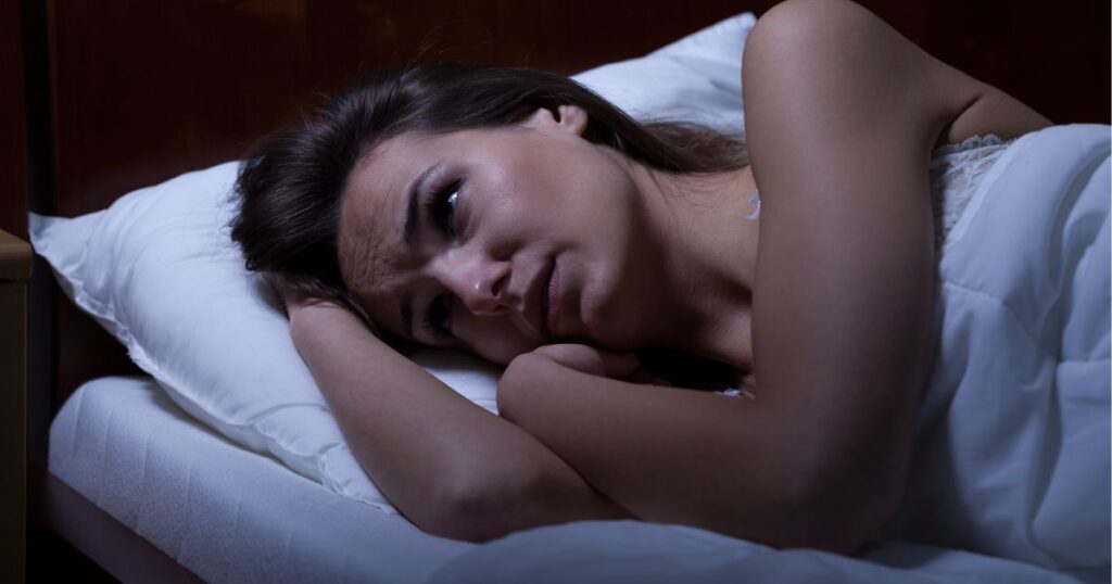 ベッドの中で眠れない女性