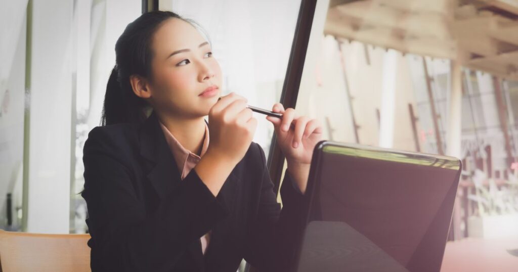 パソコンの前で考え事をする女性