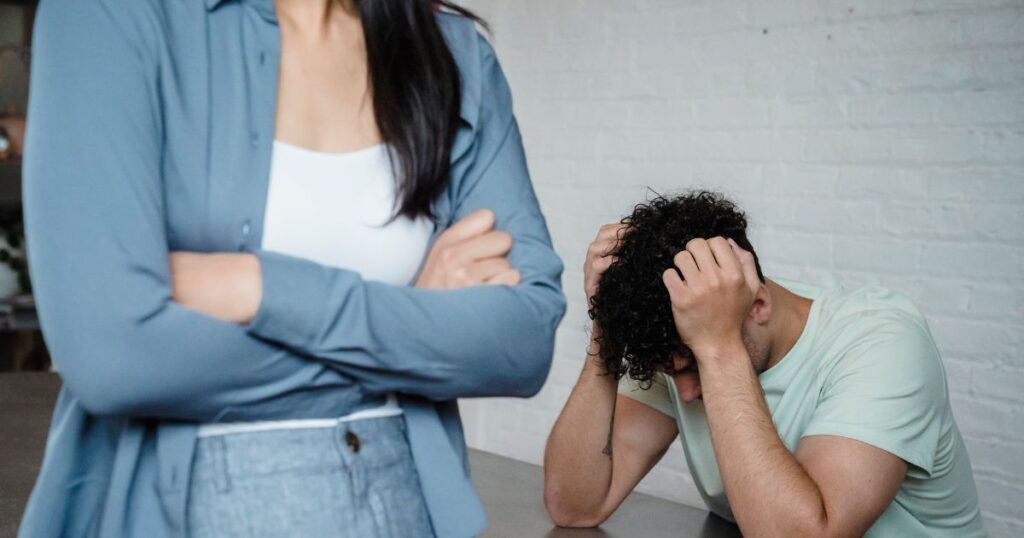 怒って腕を組む女性と頭を抱える男性