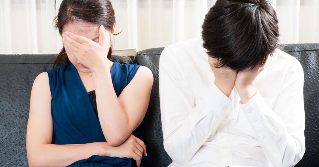 後悔で顔を覆う男女