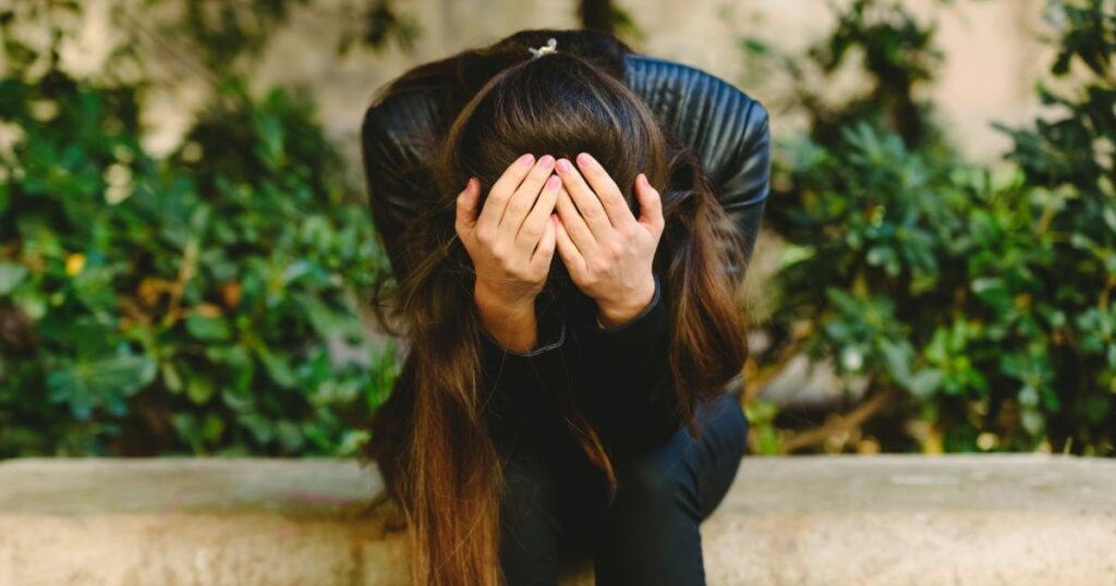 困って頭を抱える女性