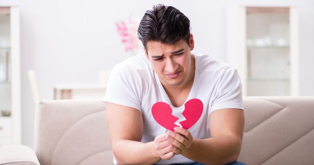 罪悪感を感じて悲しそうな表情の男性