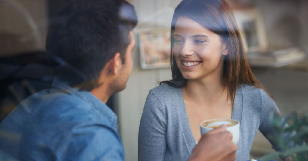 カフェで談笑しながら微笑む男女