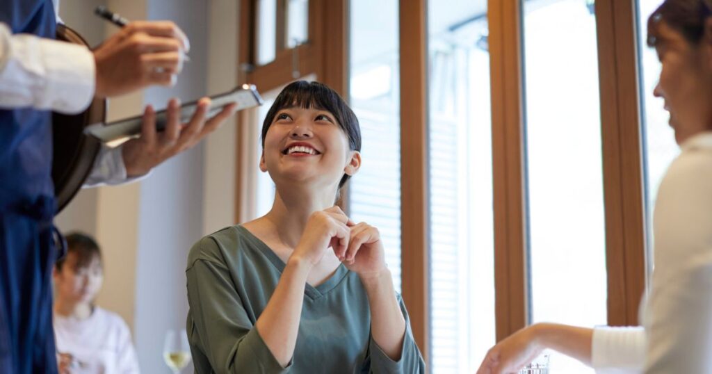 男性店員を笑顔で見つめる女性のお客さん