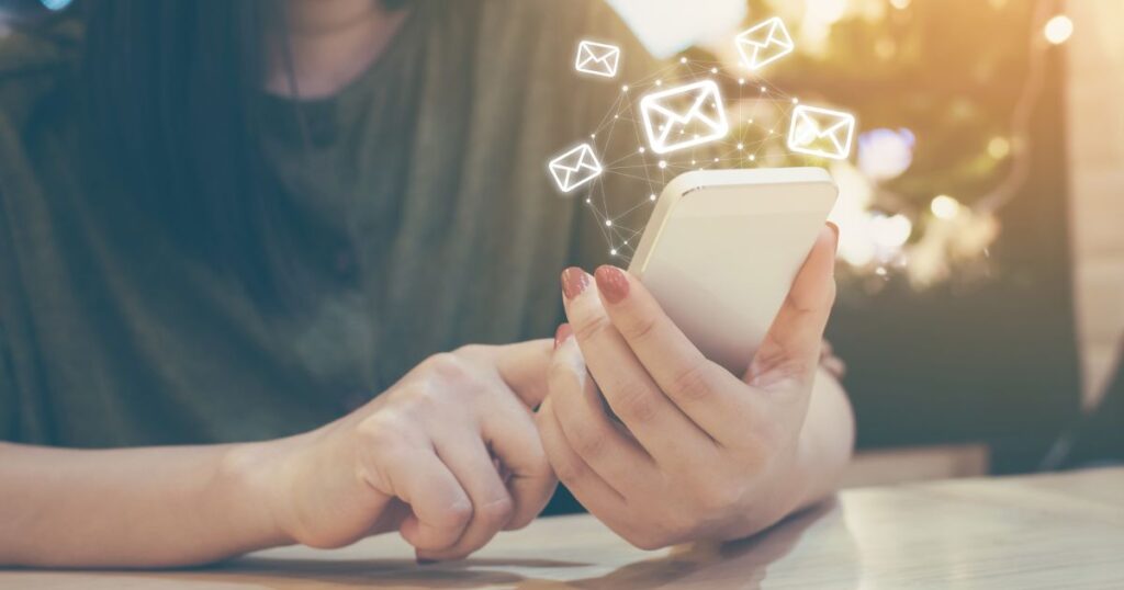 スマートフォンを操作してメールを送る女性
