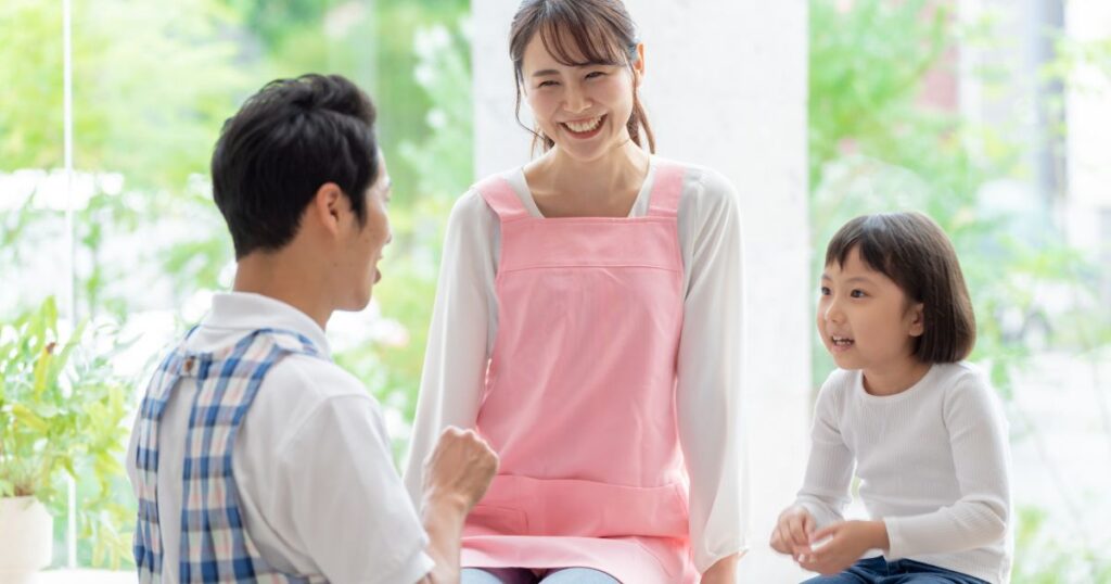 園児とお話を楽しむ男性と女性の保育士