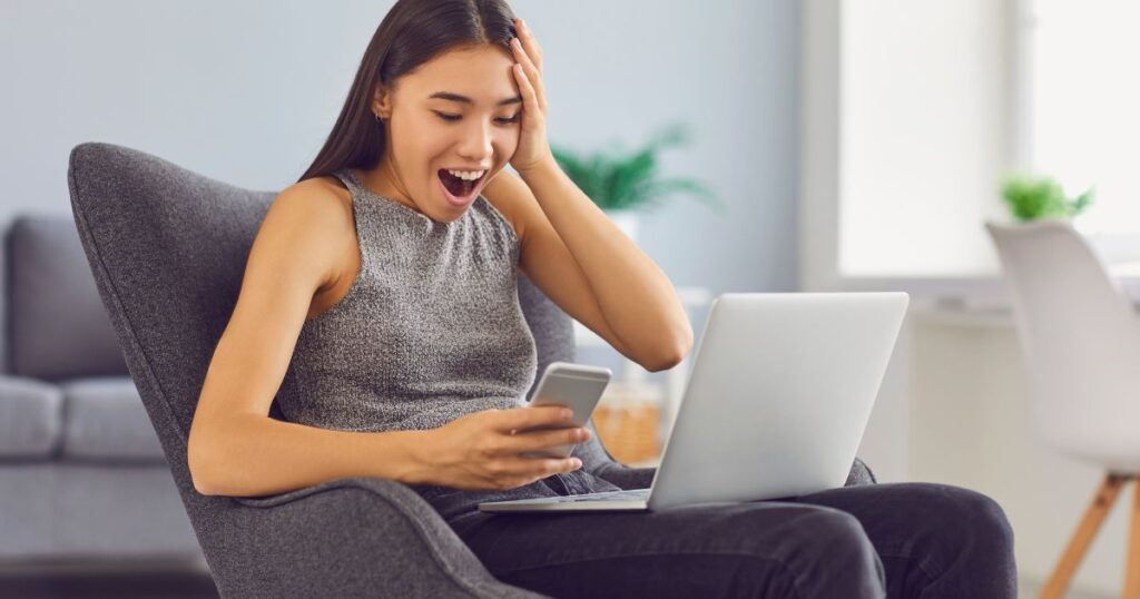スマートフォンの通知に喜ぶ女性