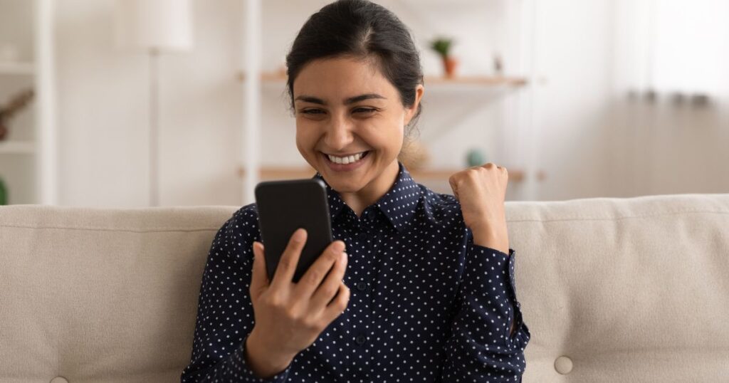 スマホの通知にガッツポーズする女性