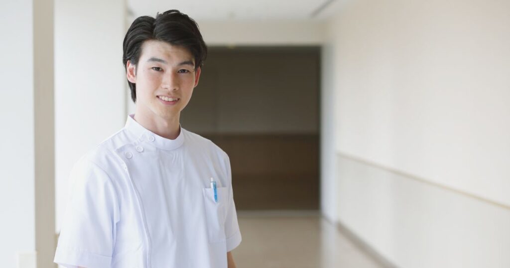 病院の廊下に立つ男性看護師