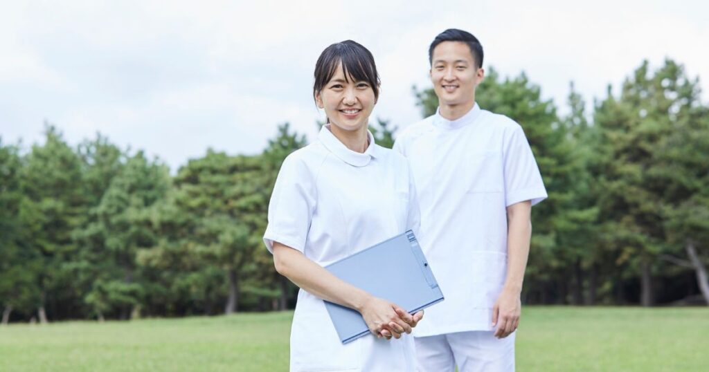 女性看護師の後ろに立つ男性看護師