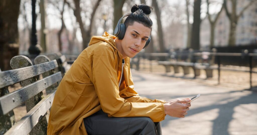 ベンチに座ってスマートフォンを操作する男性