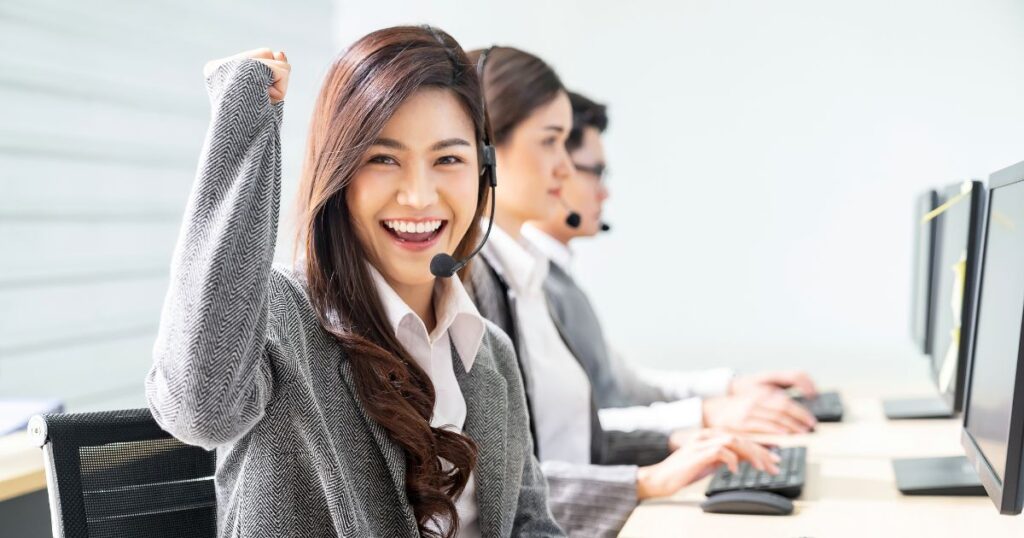 コールセンターでガッツポーズを取る女性スタッフ