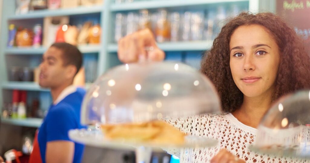 トレーで食品を運ぶ女性店員