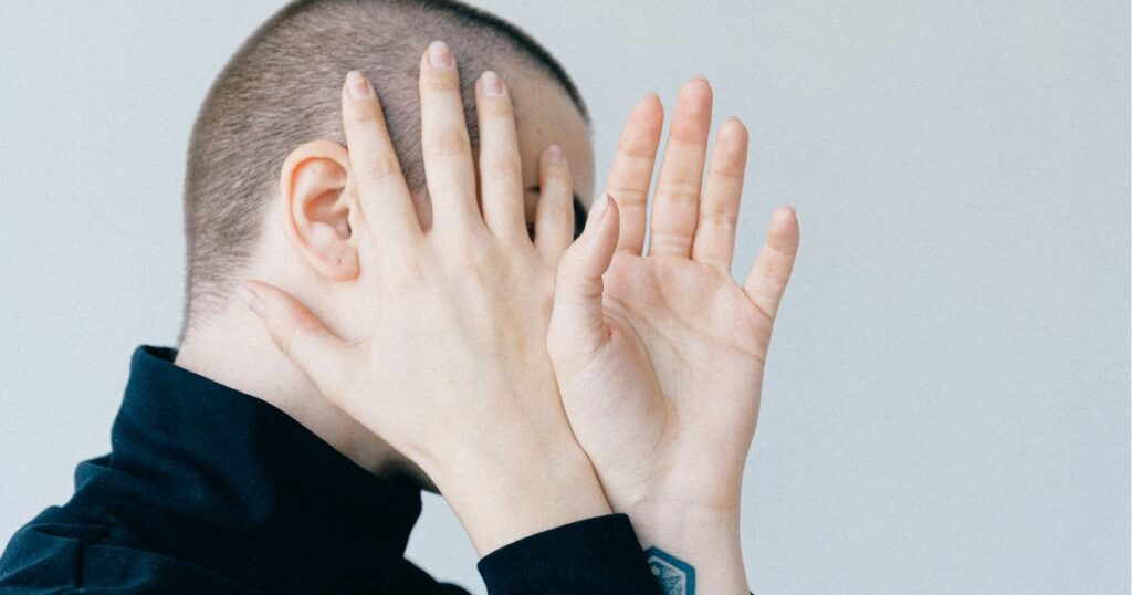 恥ずかしそうに顔を隠す男性