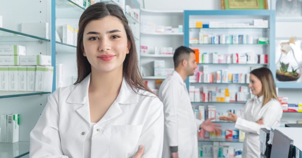 話し合う男女の薬剤師とその前で腕を組んで微笑む女性薬剤師