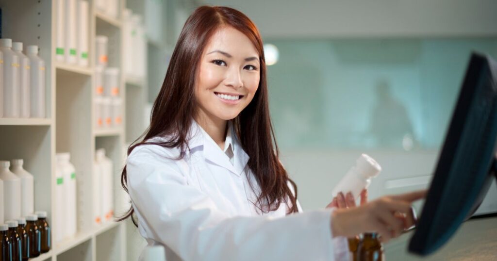 薬品いついてパソコンで調べる女性薬剤師