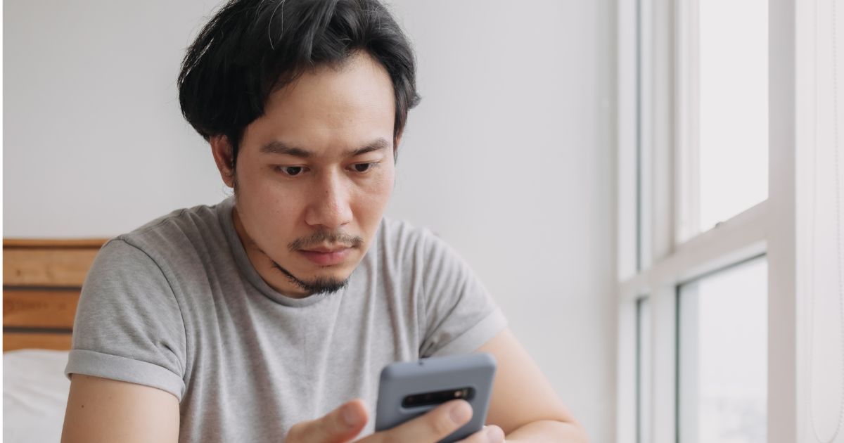 スマホの通知を見つめる男性